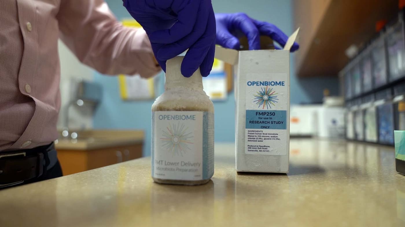 Closeup of bottle containing the sample being removed from its packaging box on a counter in the doctor's office. 